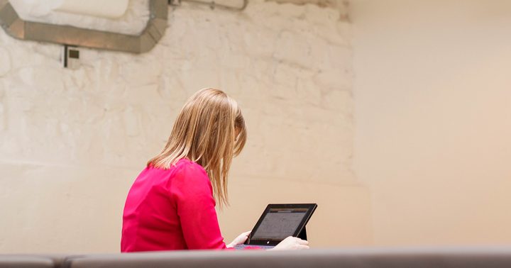 A woman working on a tablet in a meeting room