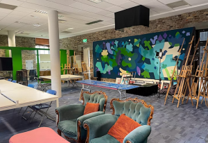 Picture of Block T event space, with chairs tables and multicoloured walls.