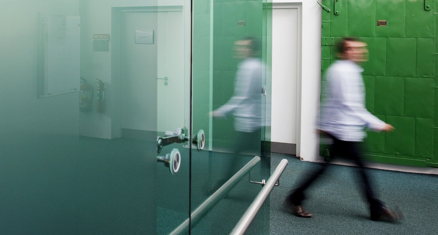A man walks through the modern corridors of the Digital Depot building at The Digital Hub.